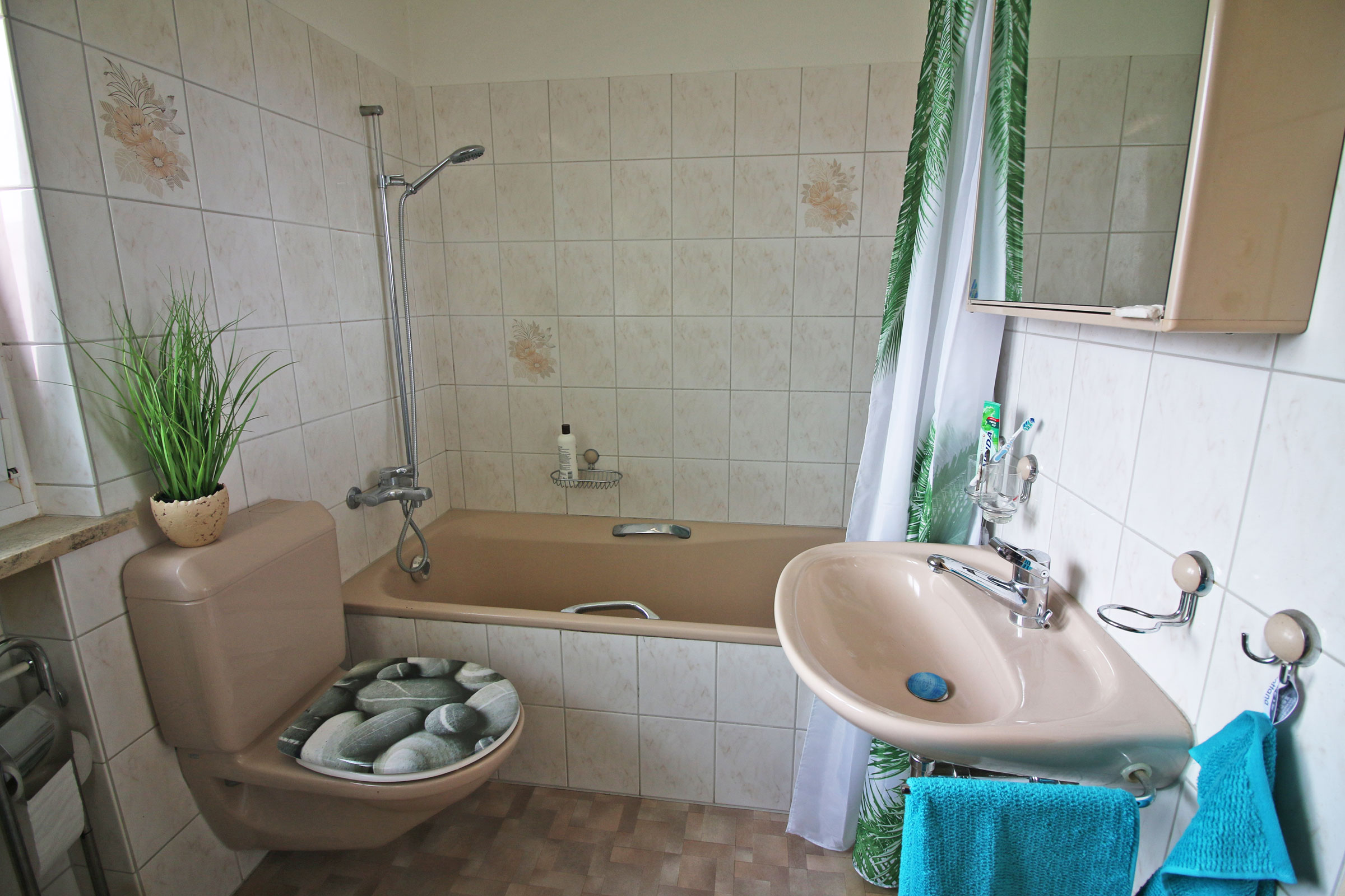 Beigefarbenes Badezimmer mit Wanne und WC