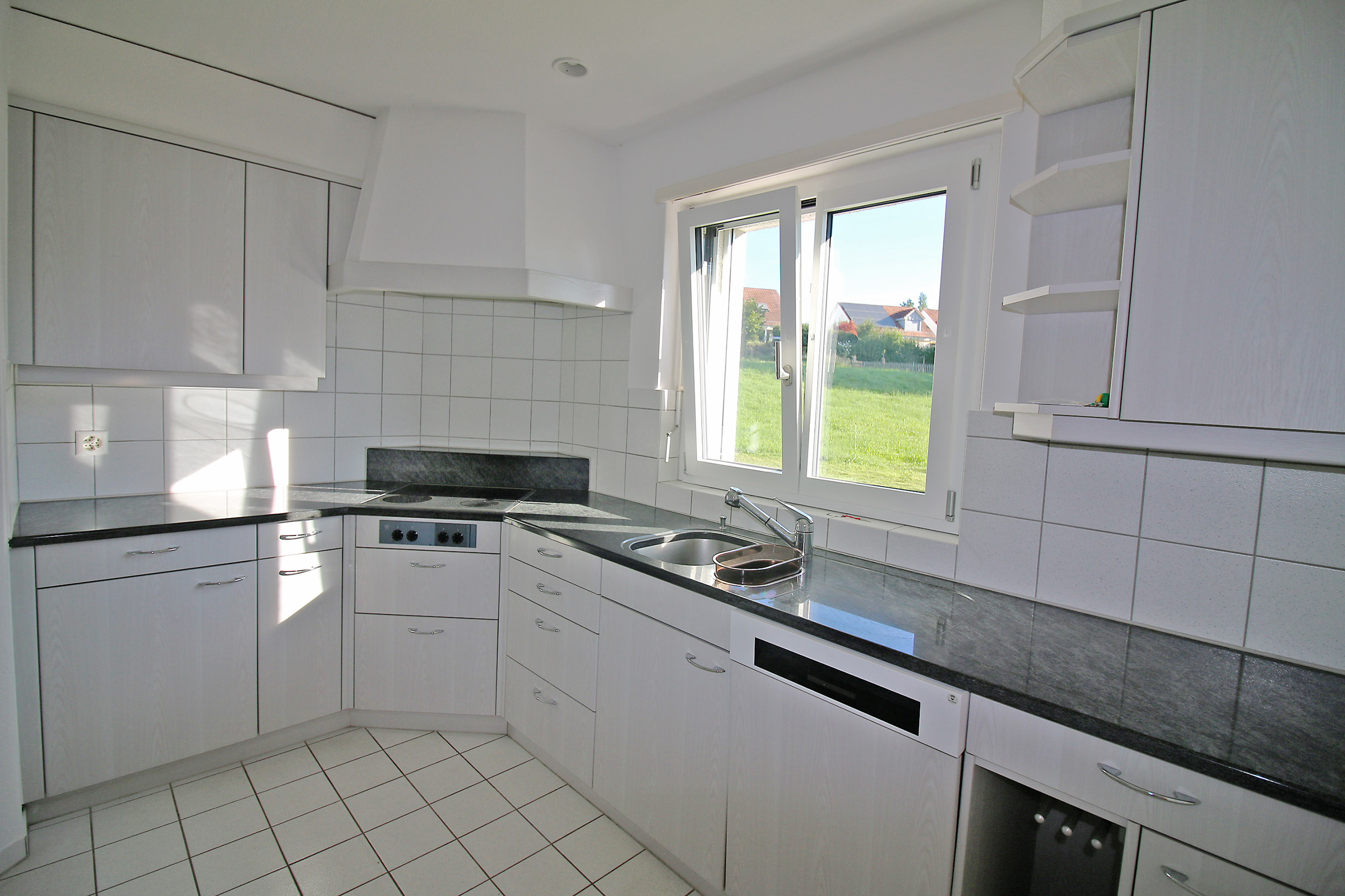 Helle, kompakte Küche mit Fenster zum Garten