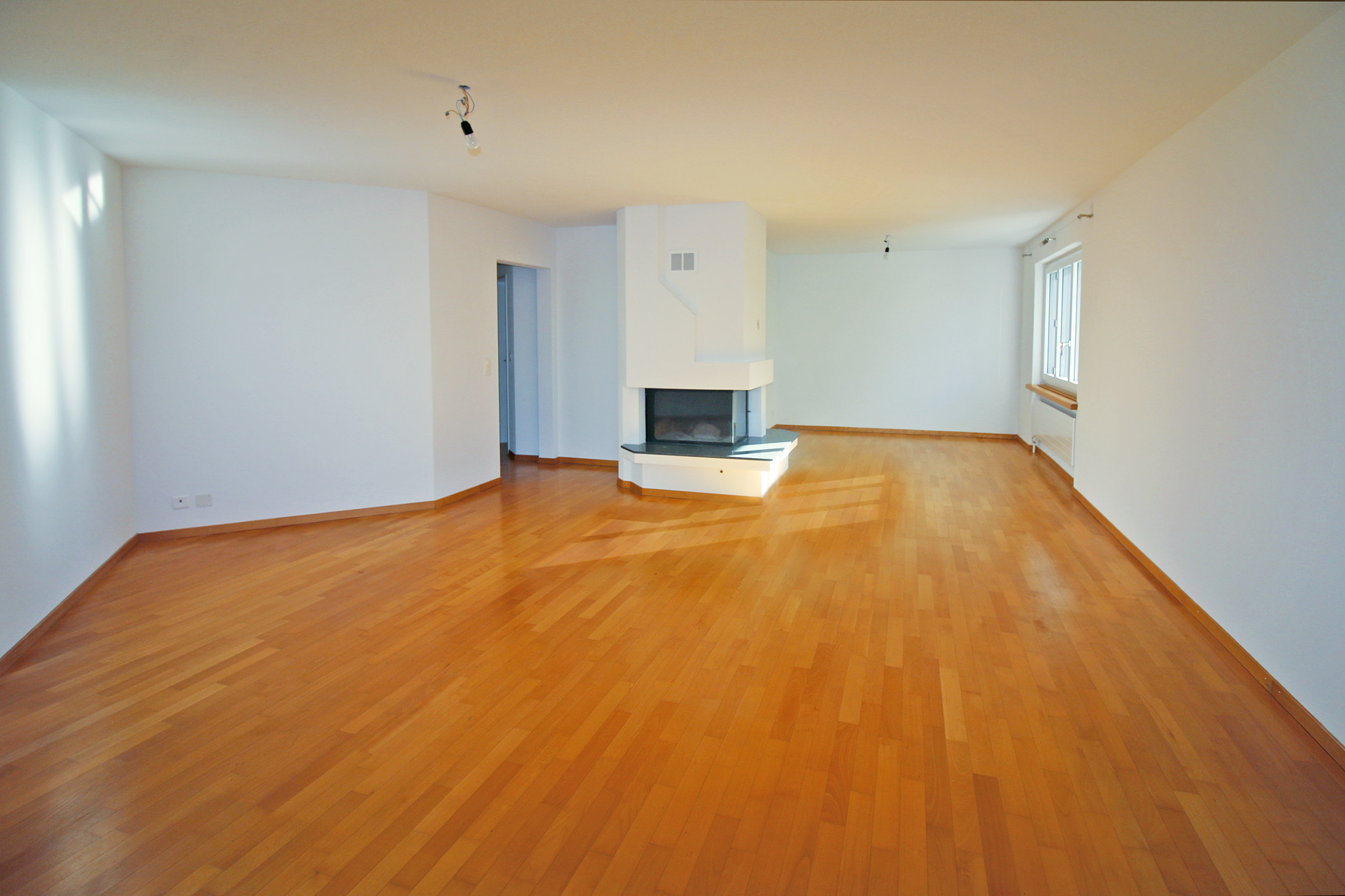 Großer leerer Wohnraum mit Kamin