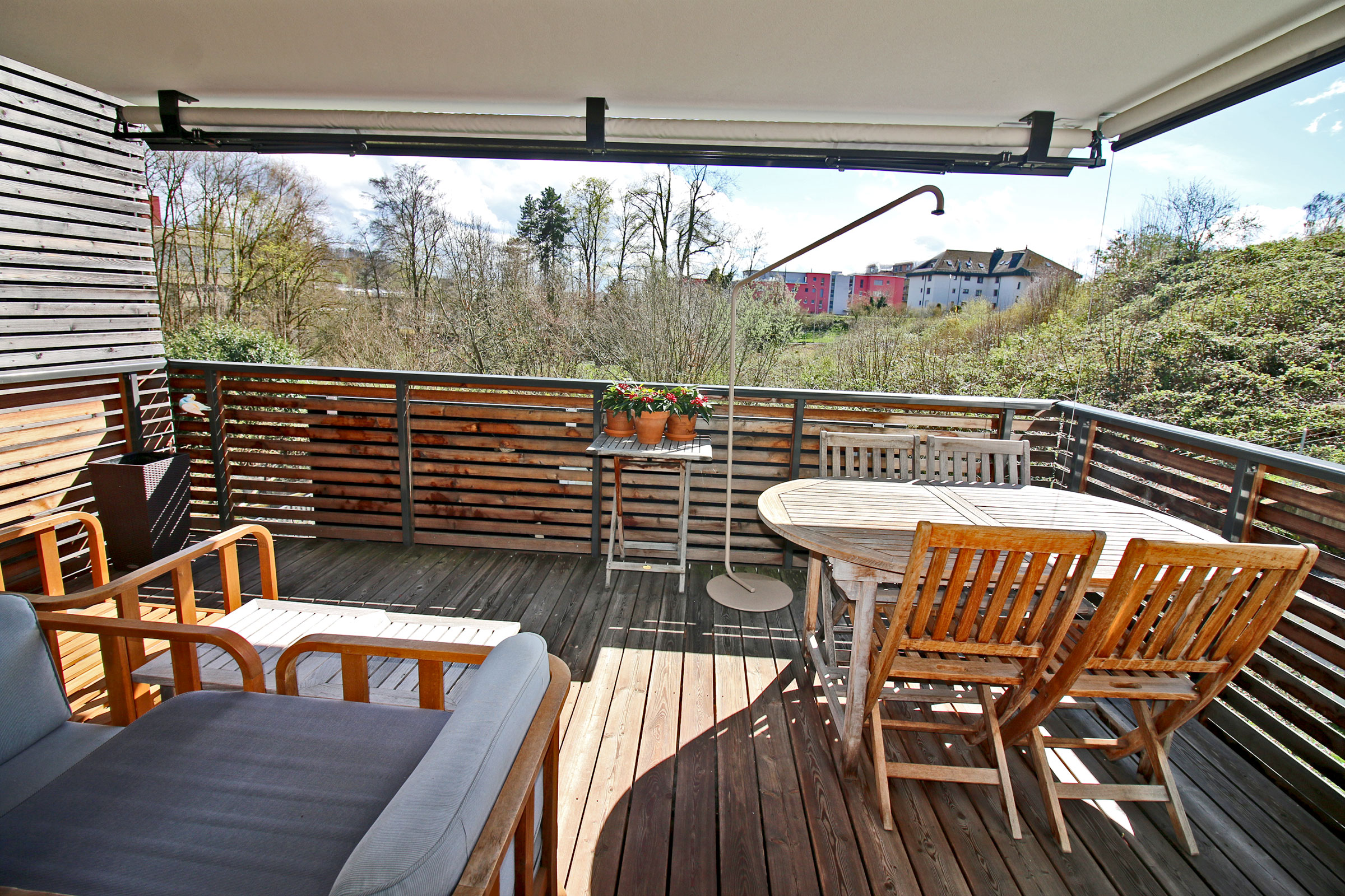 Überdachte Dachterrasse mit Sitz- und Essbereich