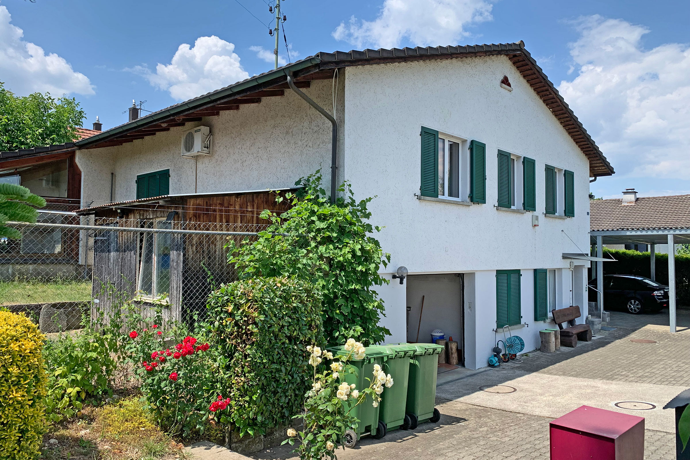 Außenansicht eines Wohnhauses mit Garten und Carport
