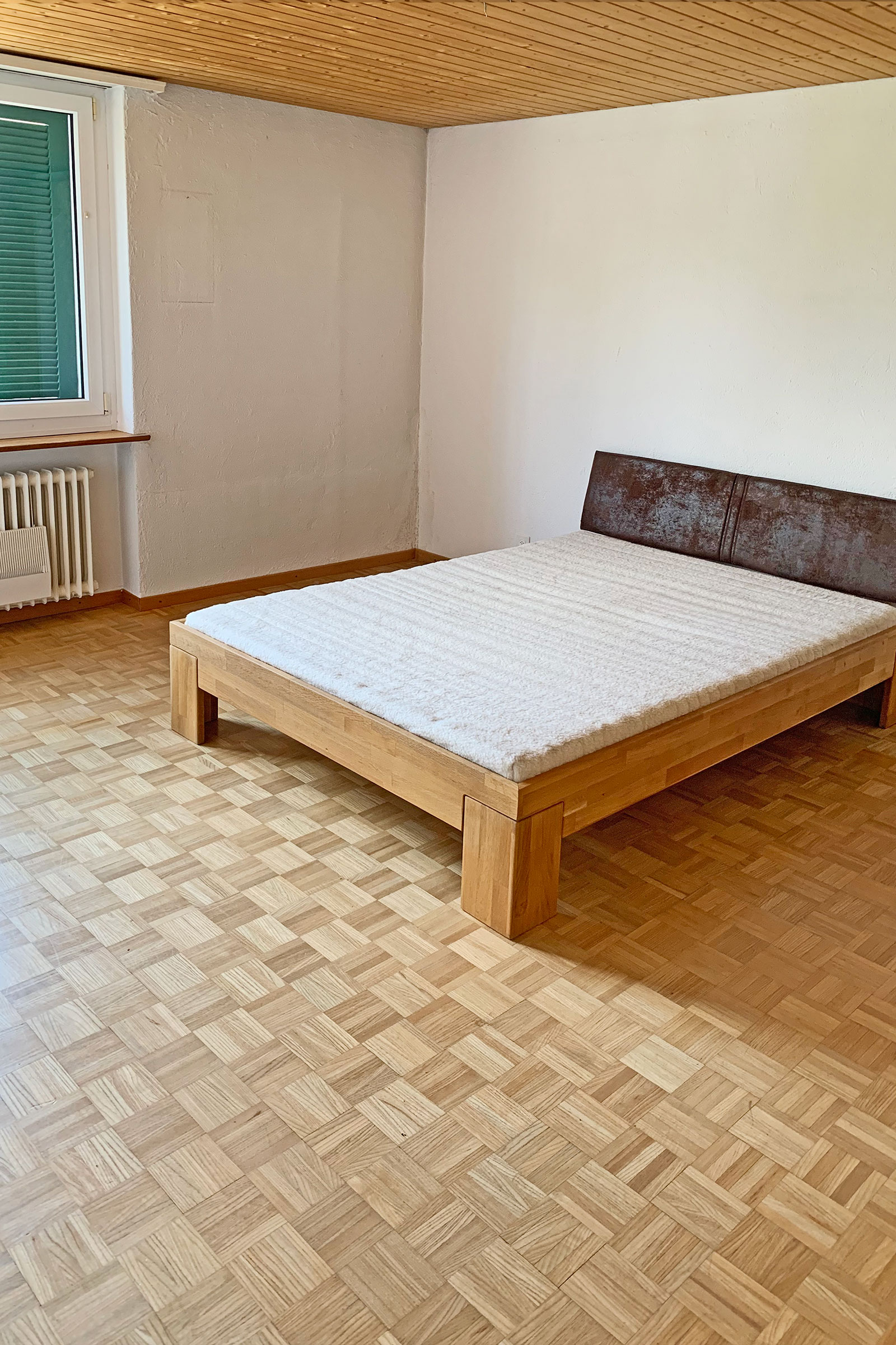 Schlafzimmer mit Bett und Parkettboden