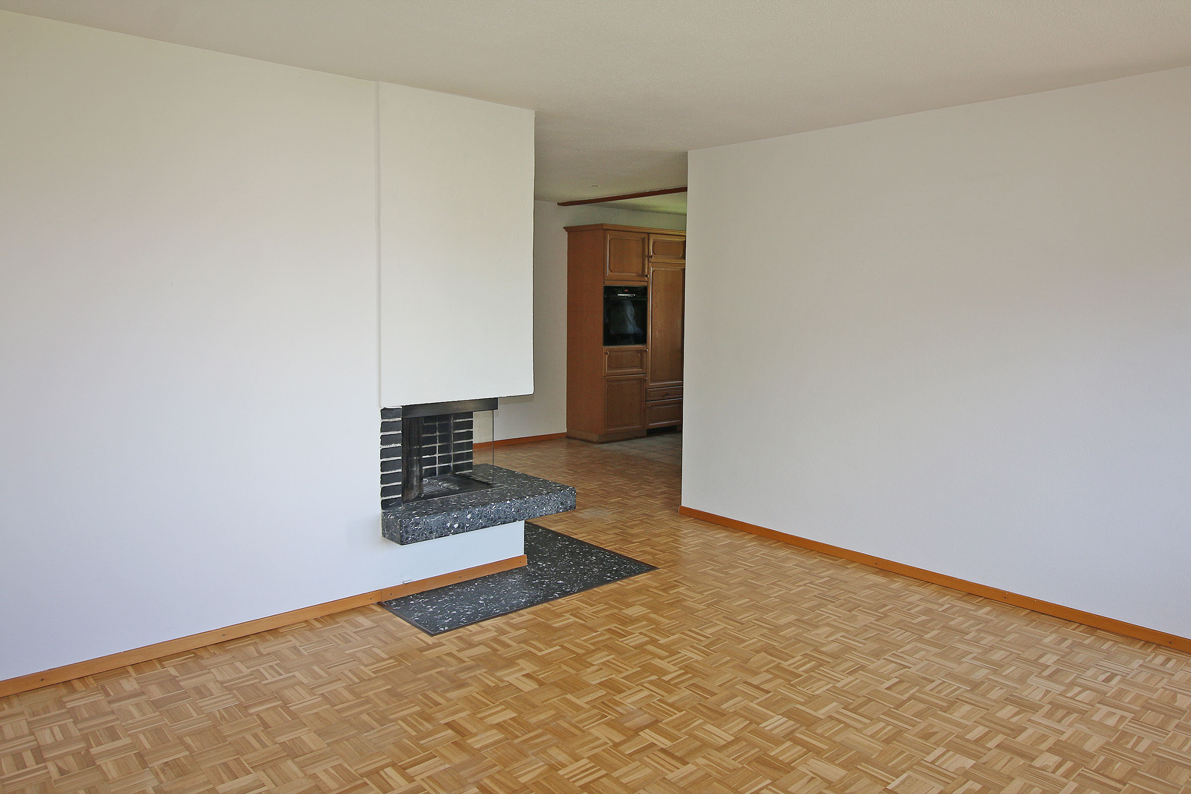 Wohnzimmer mit Kamin und Parkettboden