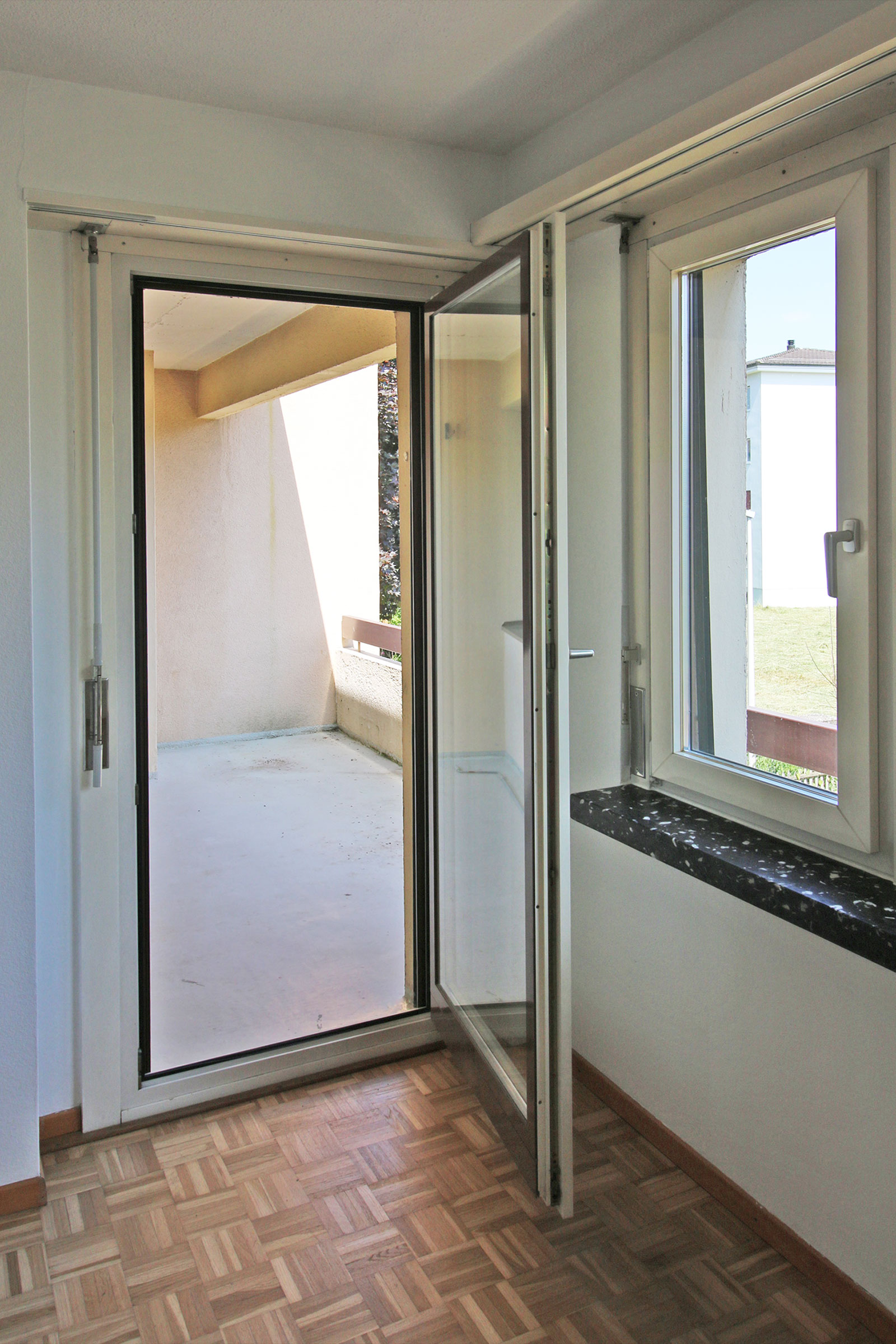 Heller Raum mit geöffneten Fenstern zur Loggia