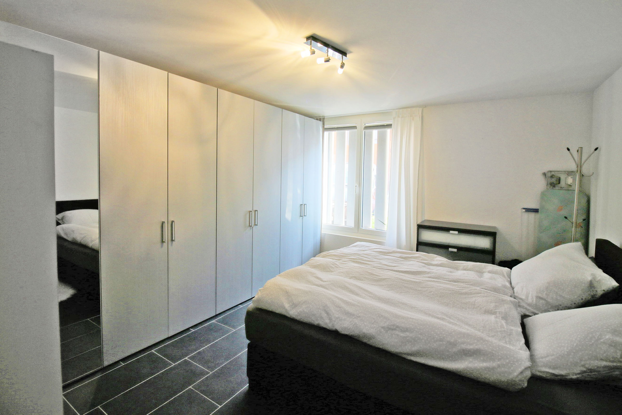Schlafzimmer mit Einbauschränken und Doppelbett