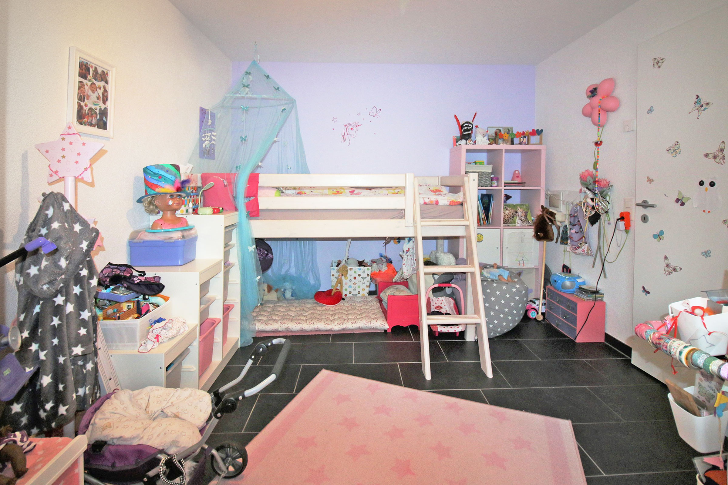 Kinderzimmer mit Hochbett und viel Spielzeug