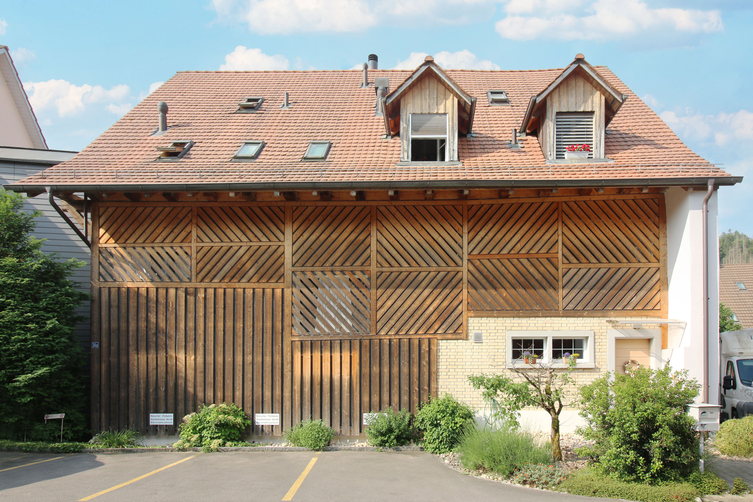 Außenansicht eines Hauses mit Satteldach und Holzfassade