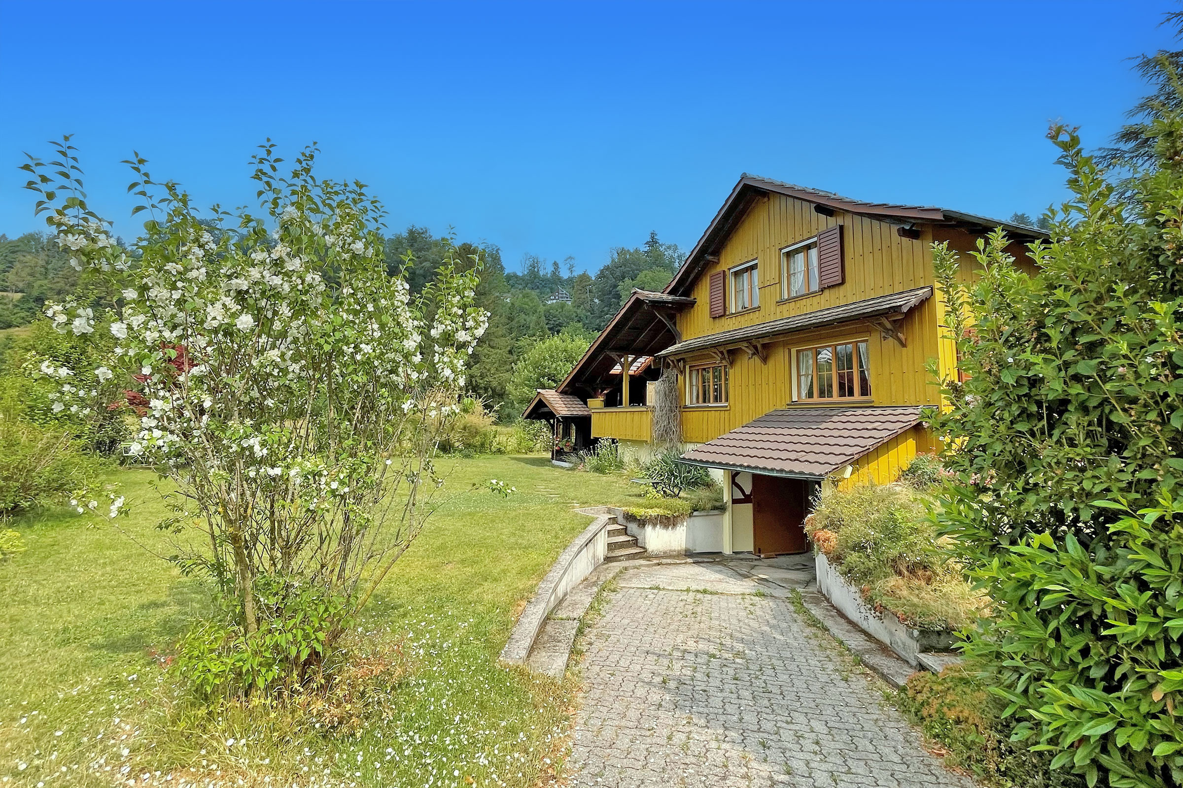 Ländliches Einfamilienhaus mit gelber Holzfassade