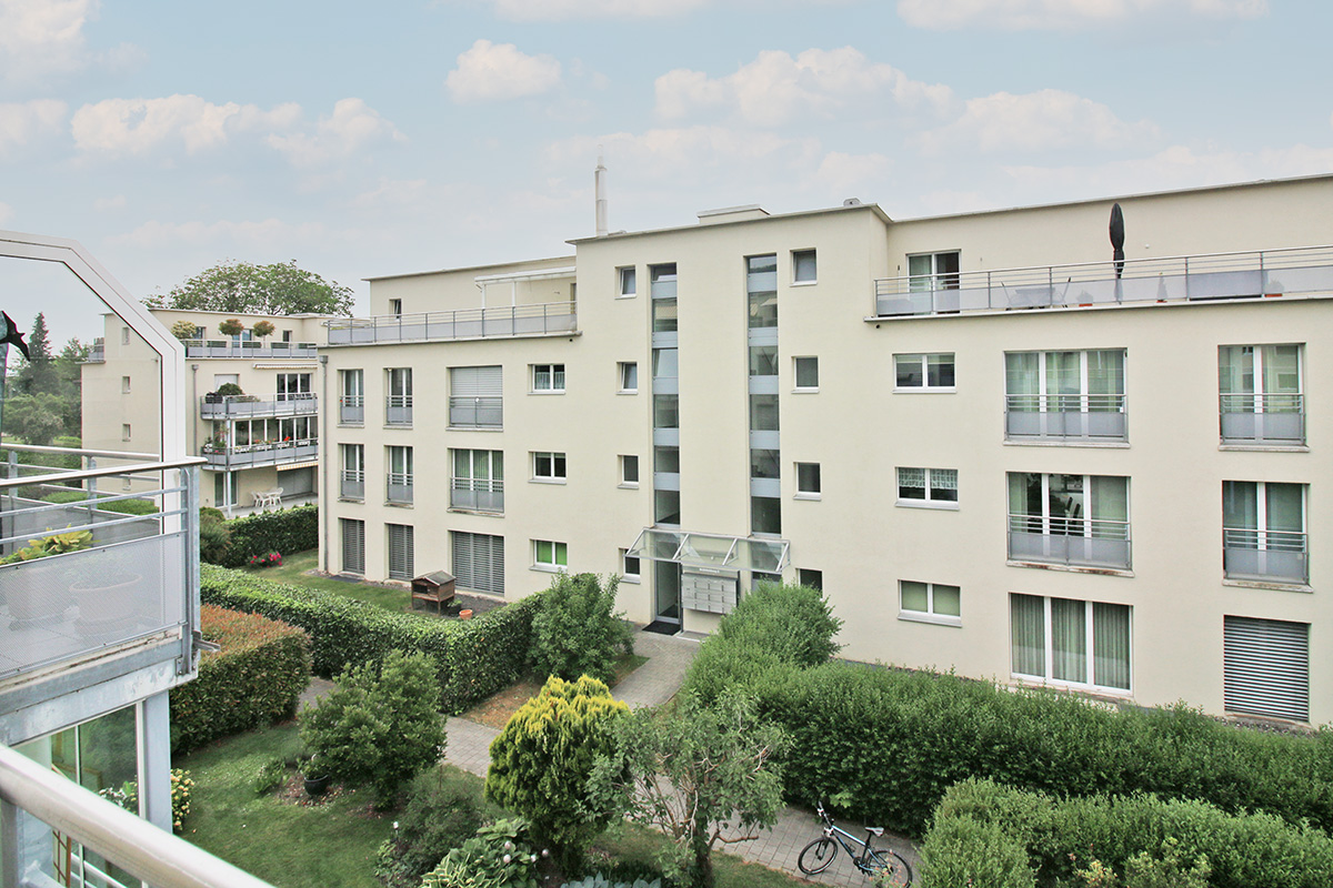 Wohnanlage mit begrüntem Innenhof und Balkonansicht