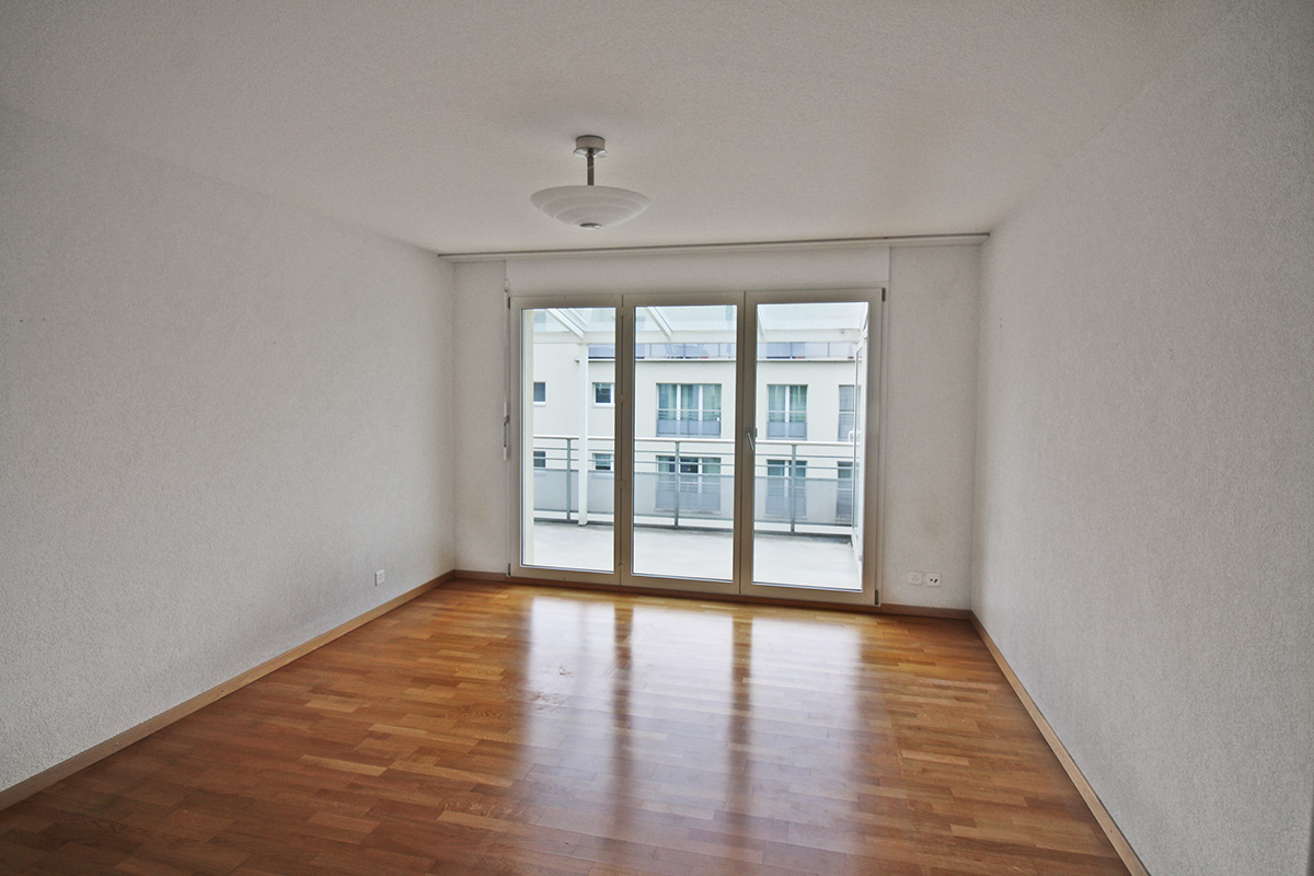 Leerer Wohnraum mit Balkonzugang
