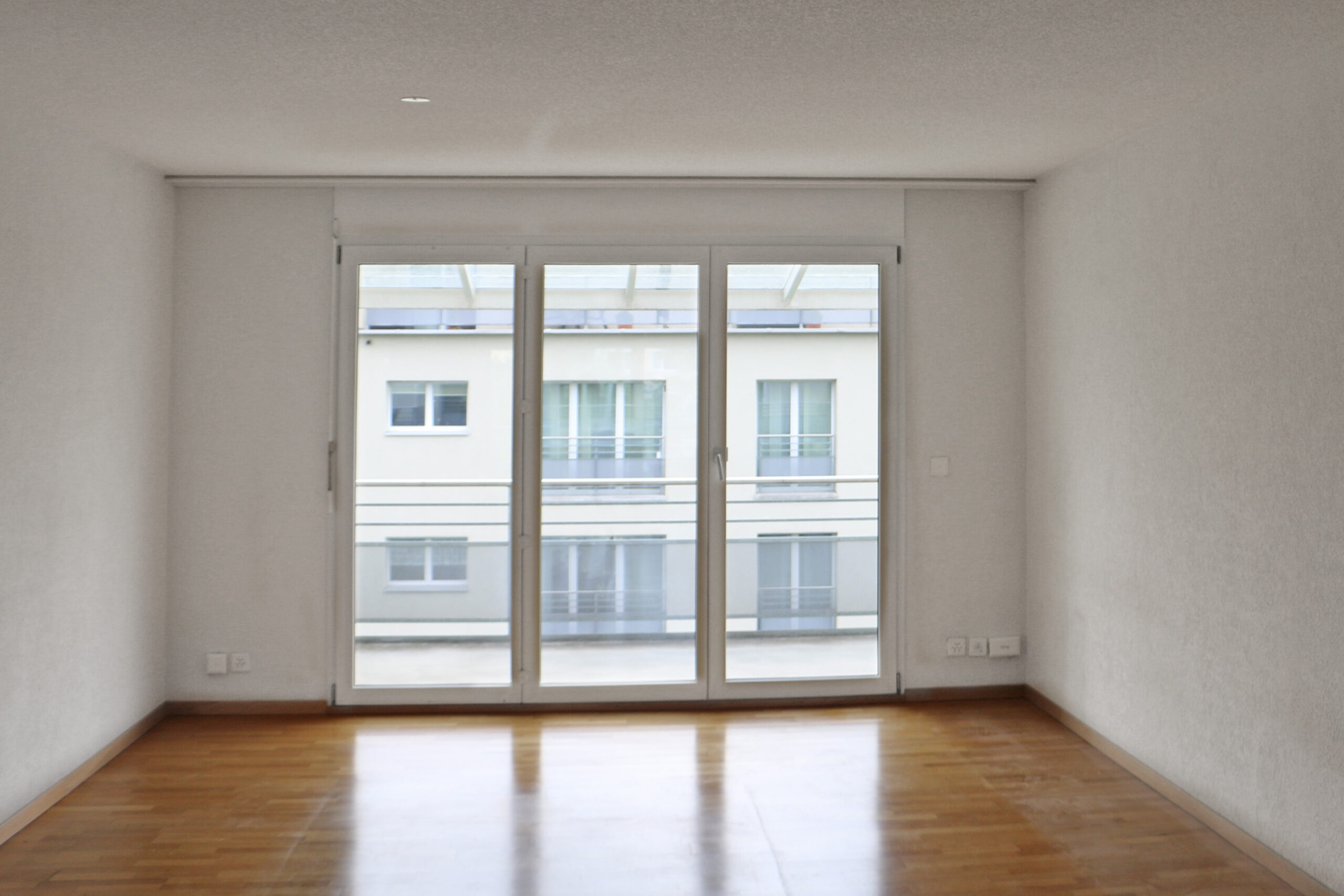 Leeres helles Zimmer mit Balkonfenster