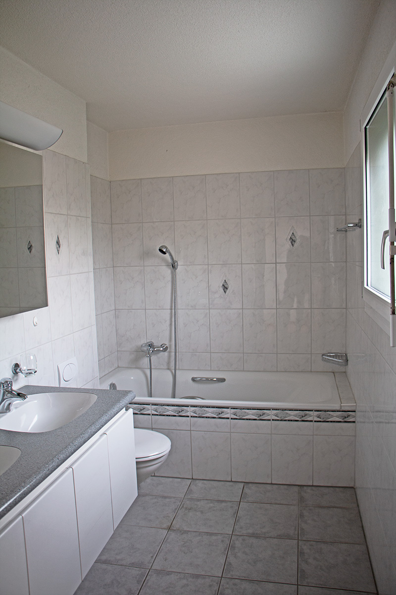 Badezimmer mit Wanne und Waschtisch