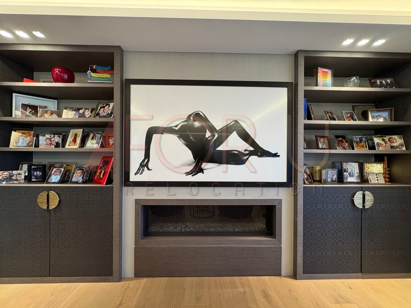 Wohnzimmer mit eingebautem Kamin und Bücherregalen