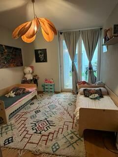 Gemütliches Schlafzimmer mit Teppich und Balkonfenster