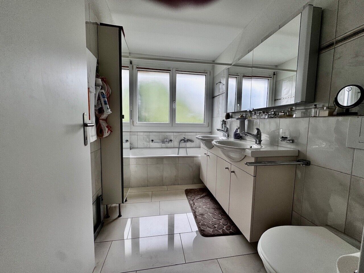 Badezimmer mit Doppelwaschtisch und Badewanne