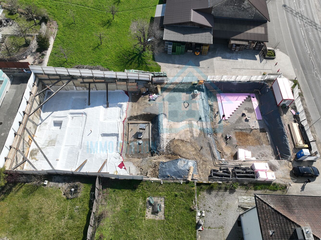 Luftaufnahme einer Baustelle mit Grundstück und Nachbargebäuden