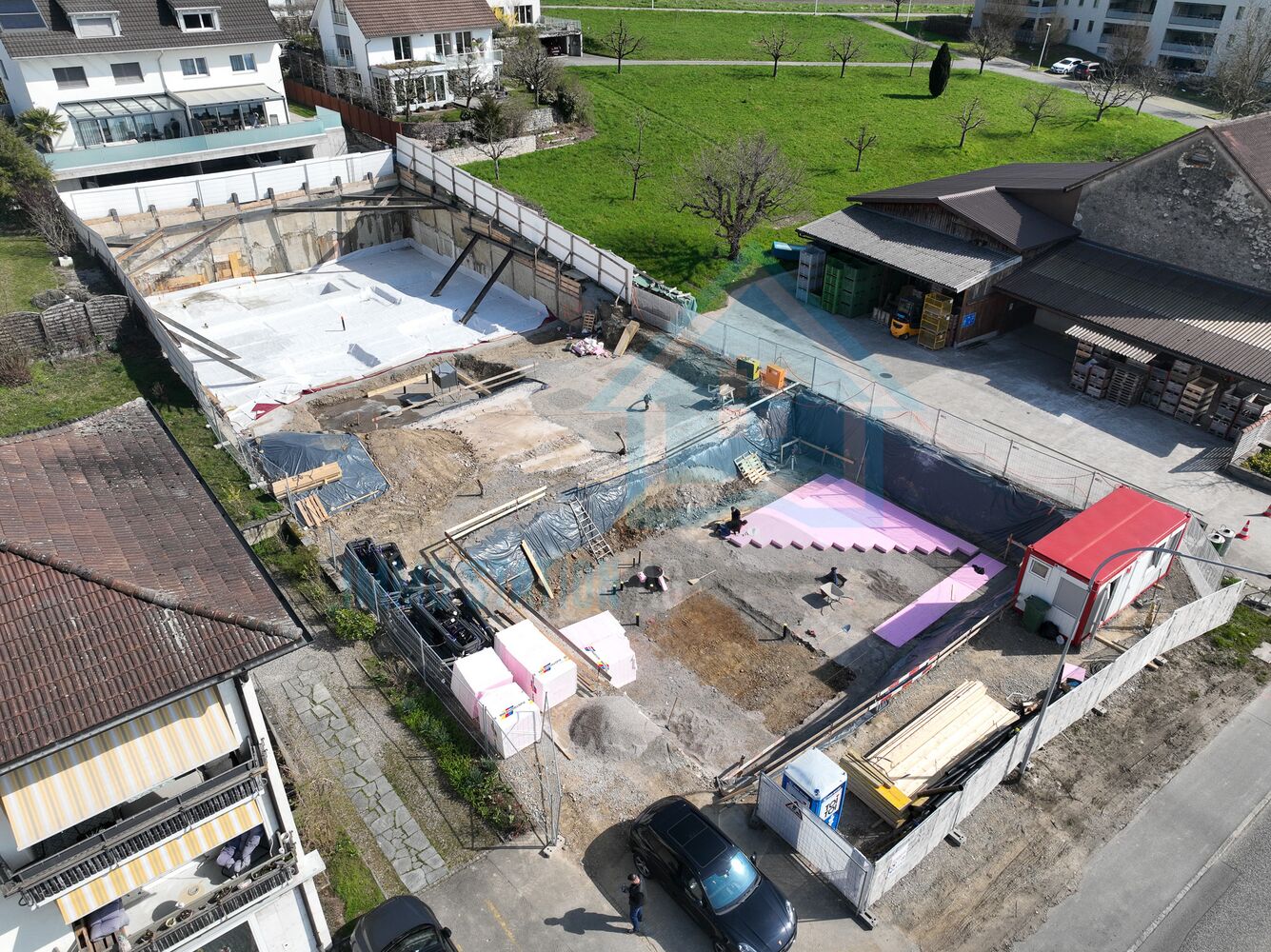 Luftaufnahme einer Baustelle neben Wohnhäusern