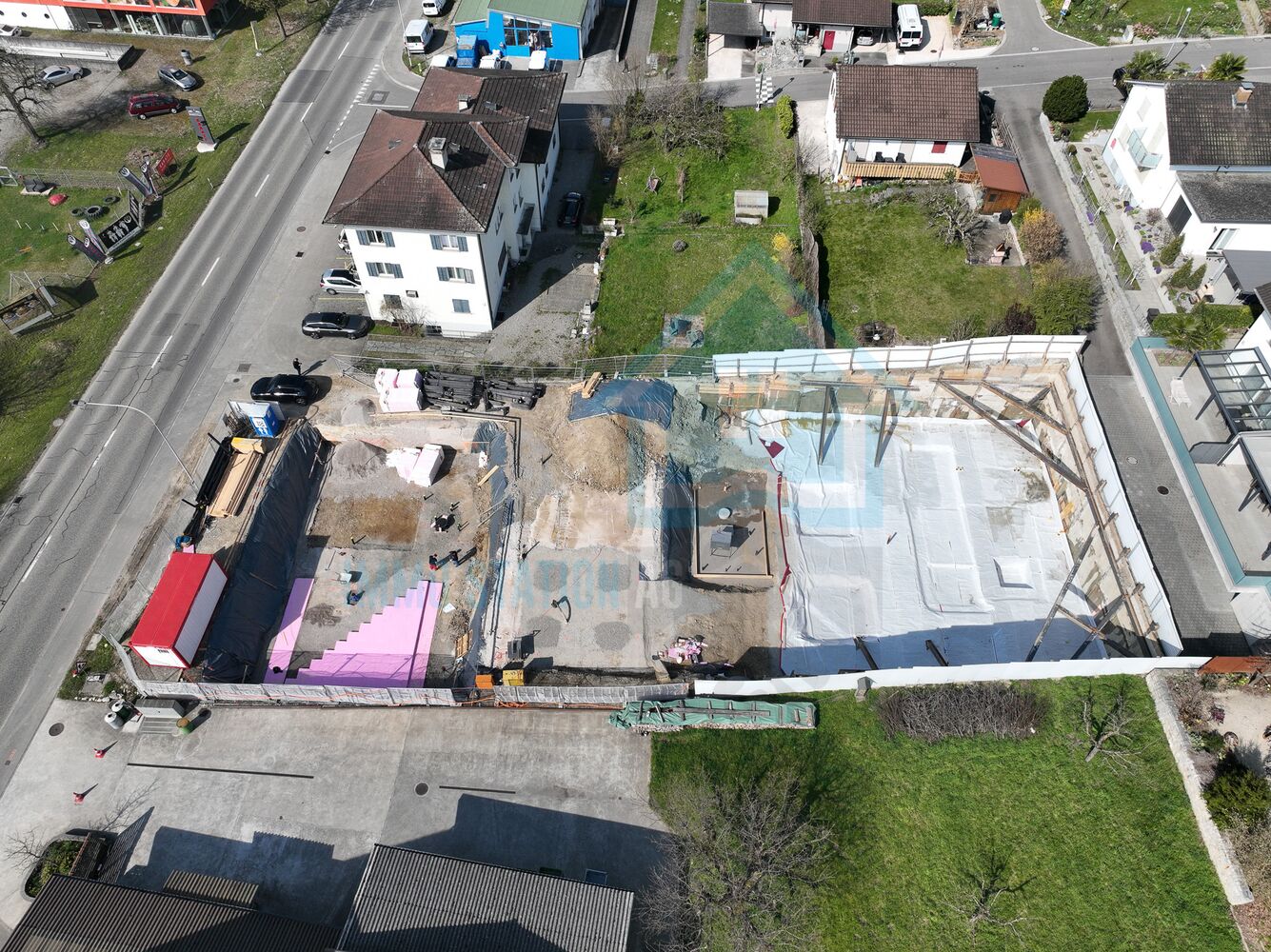 Luftaufnahme einer Baustelle neben Wohnhäusern