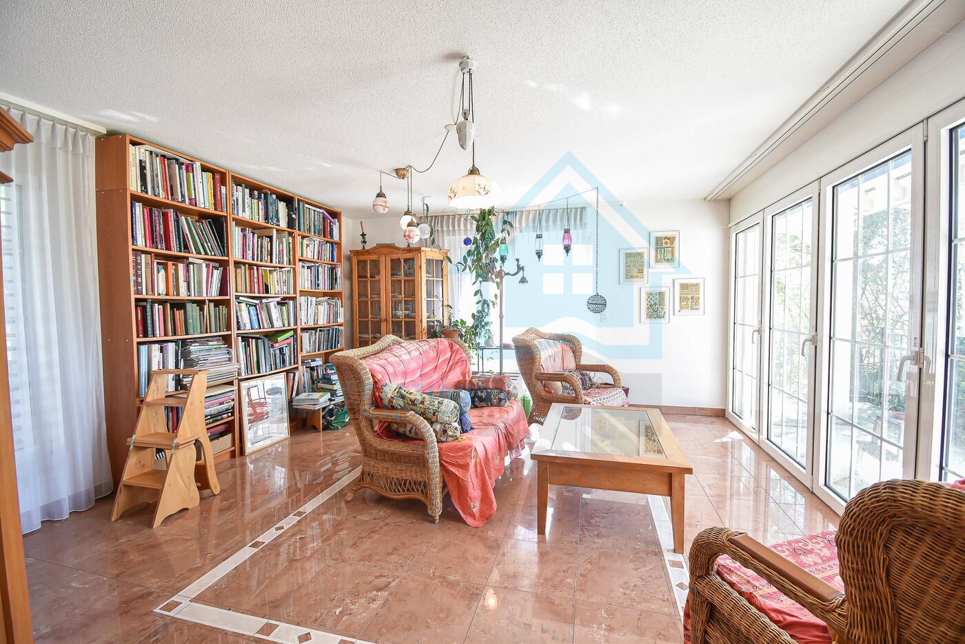 Heller Wohnraum mit Bücherregalen und Terrassentür