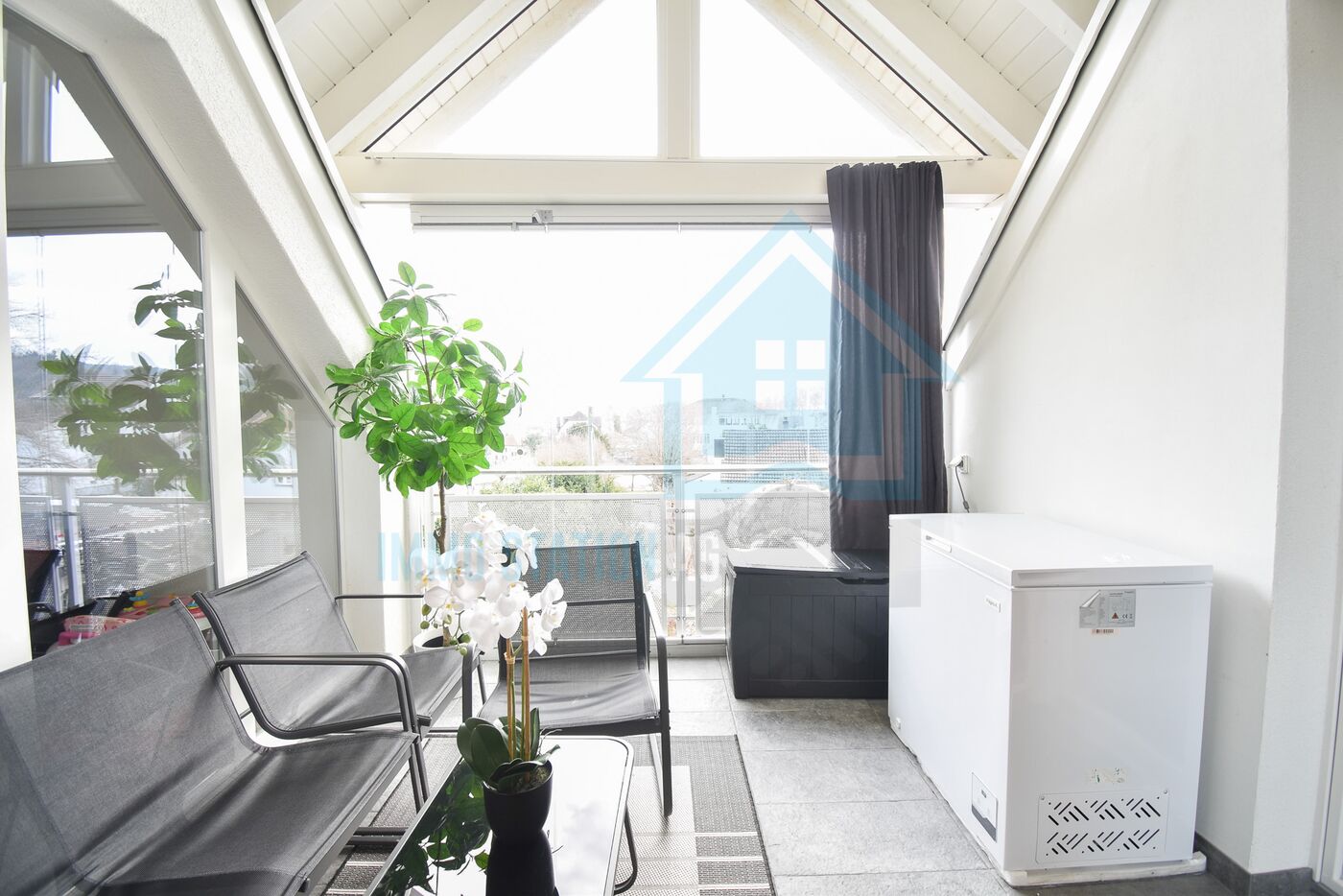Verglaster Balkon mit Sitzgruppe und Whirlpool