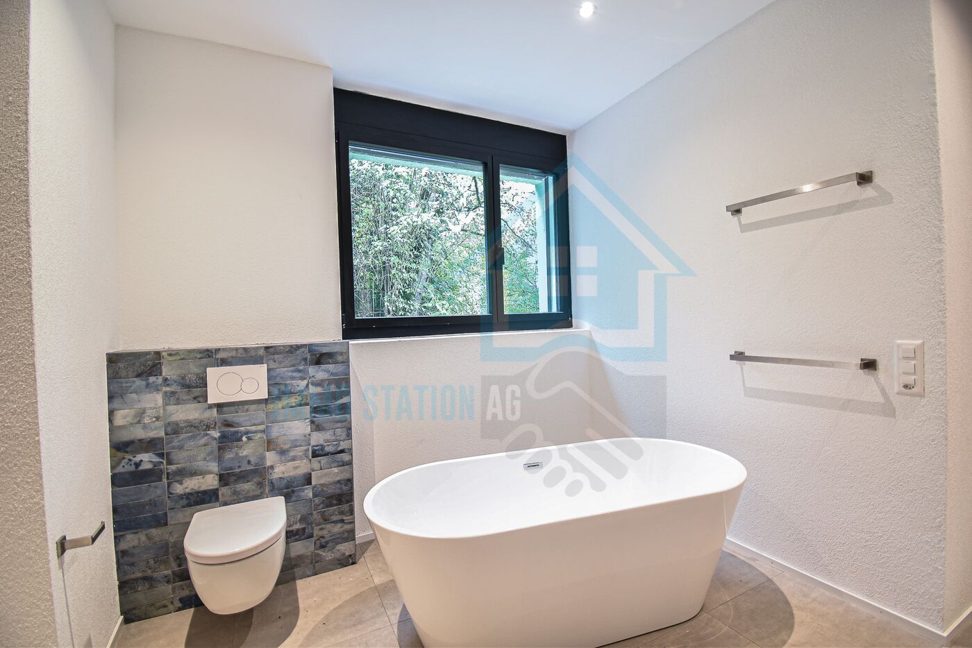 Modernes Badezimmer mit freistehender Badewanne und WC