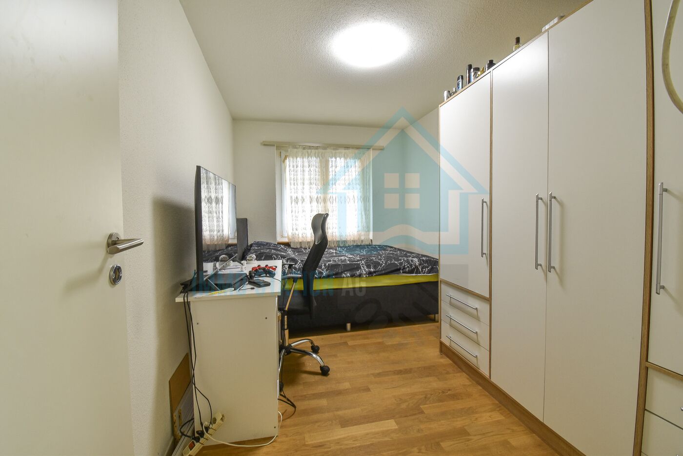 Kleines Schlafzimmer mit Schreibtisch und Einbauschrank