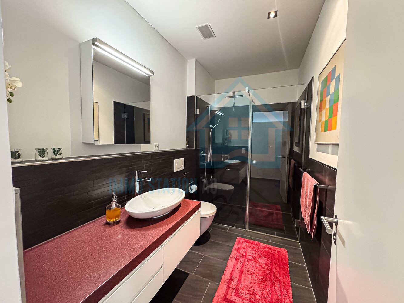 Modernes Badezimmer mit dunklen Oberflächen und Glasdusche