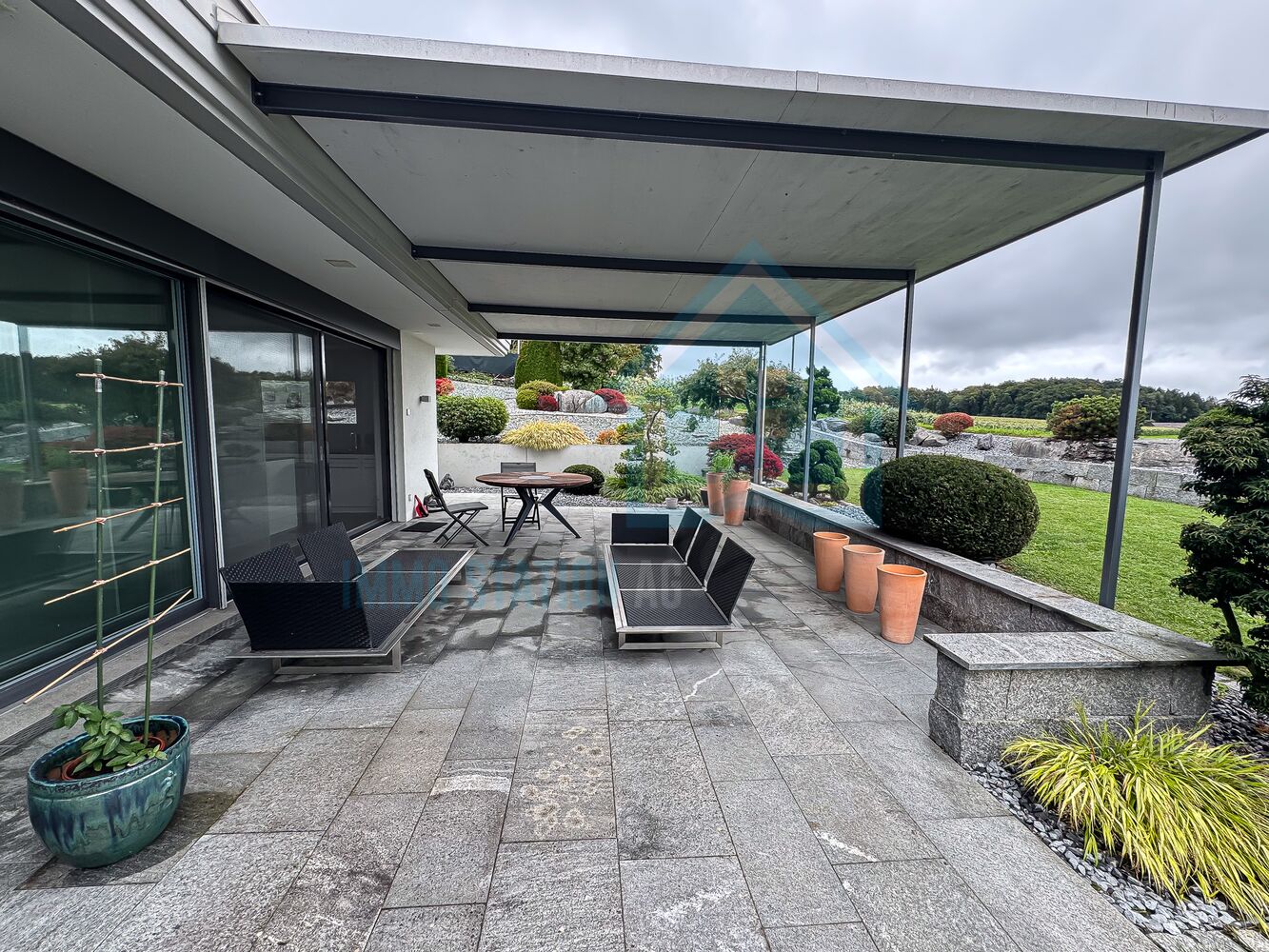 Überdachte Terrasse mit Gartenblick
