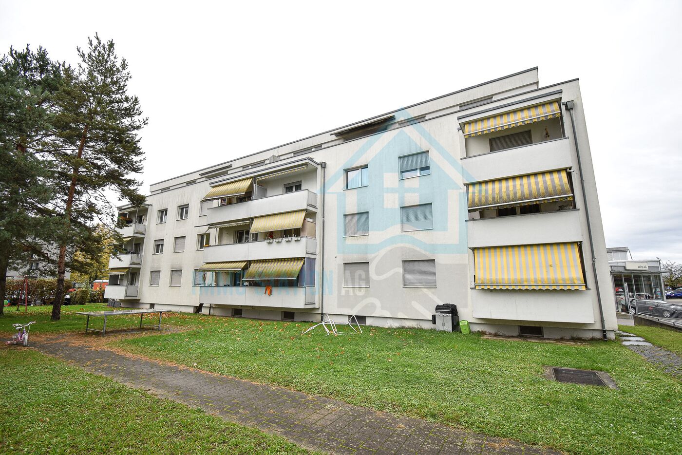 Mehrfamilienhaus mit Balkonen und Markisen