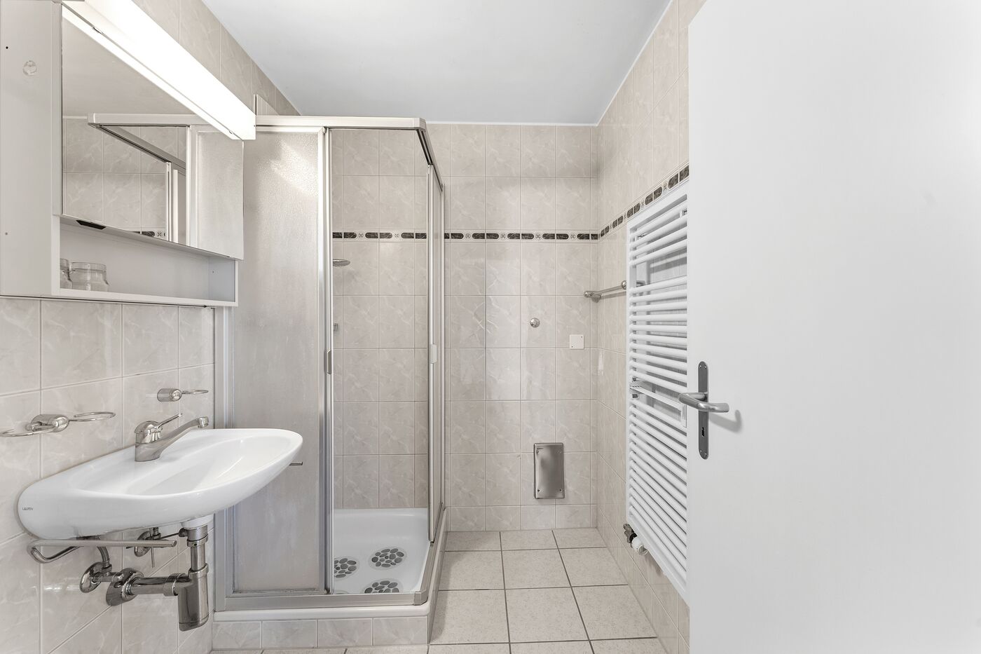 Helles, kleines Badezimmer mit Dusche und Waschbecken