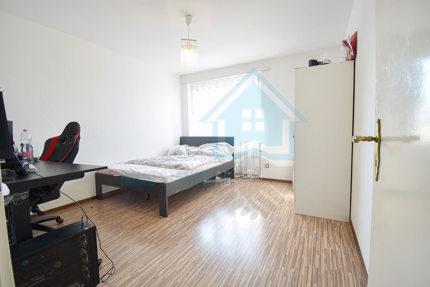 Helles Schlafzimmer mit Schreibtisch und Kleiderschrank