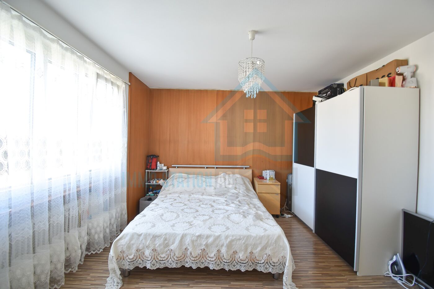 Schlafzimmer mit großem Fenster und Holzvertäfelung