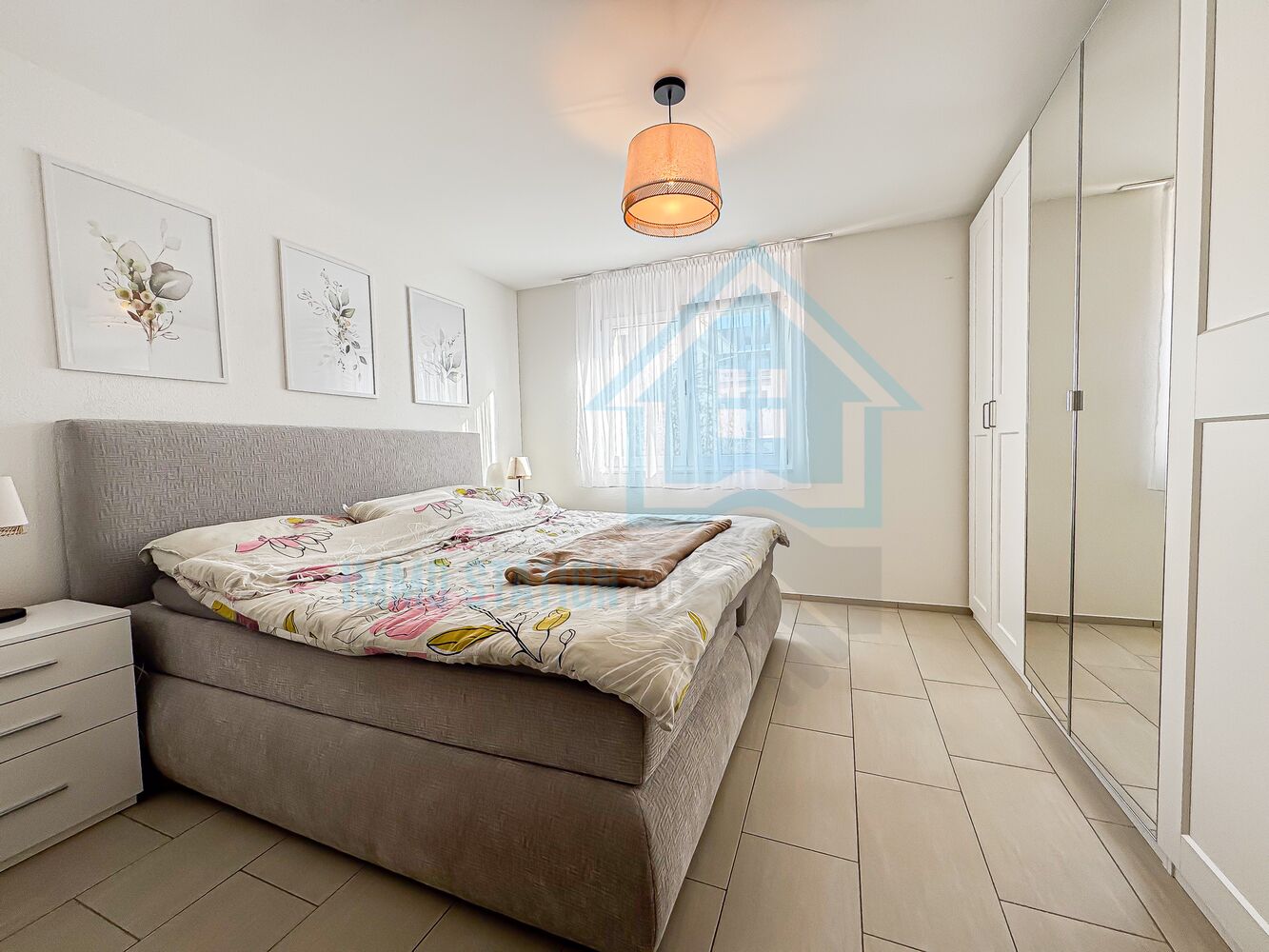 Helles Schlafzimmer mit großem Bett und Kleiderschrank