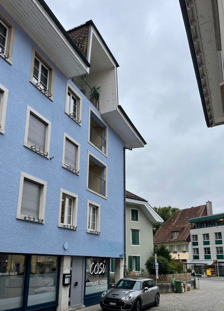 Straßenansicht mit blauem Mehrfamilienhaus