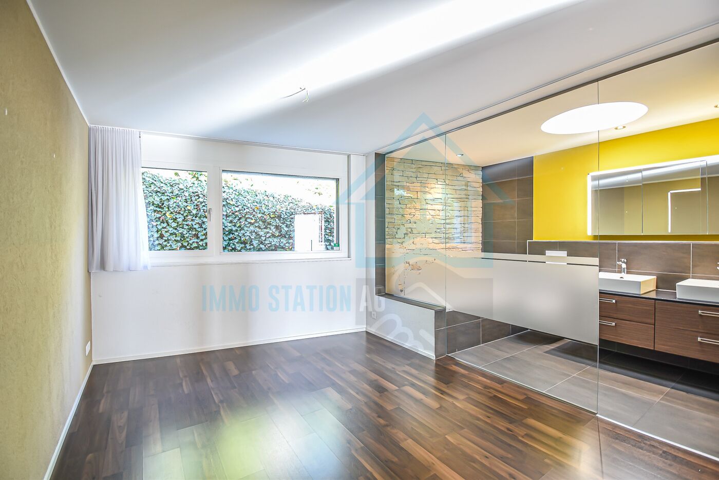 Modernes Badezimmer mit Holzoptik und Glasabtrennung