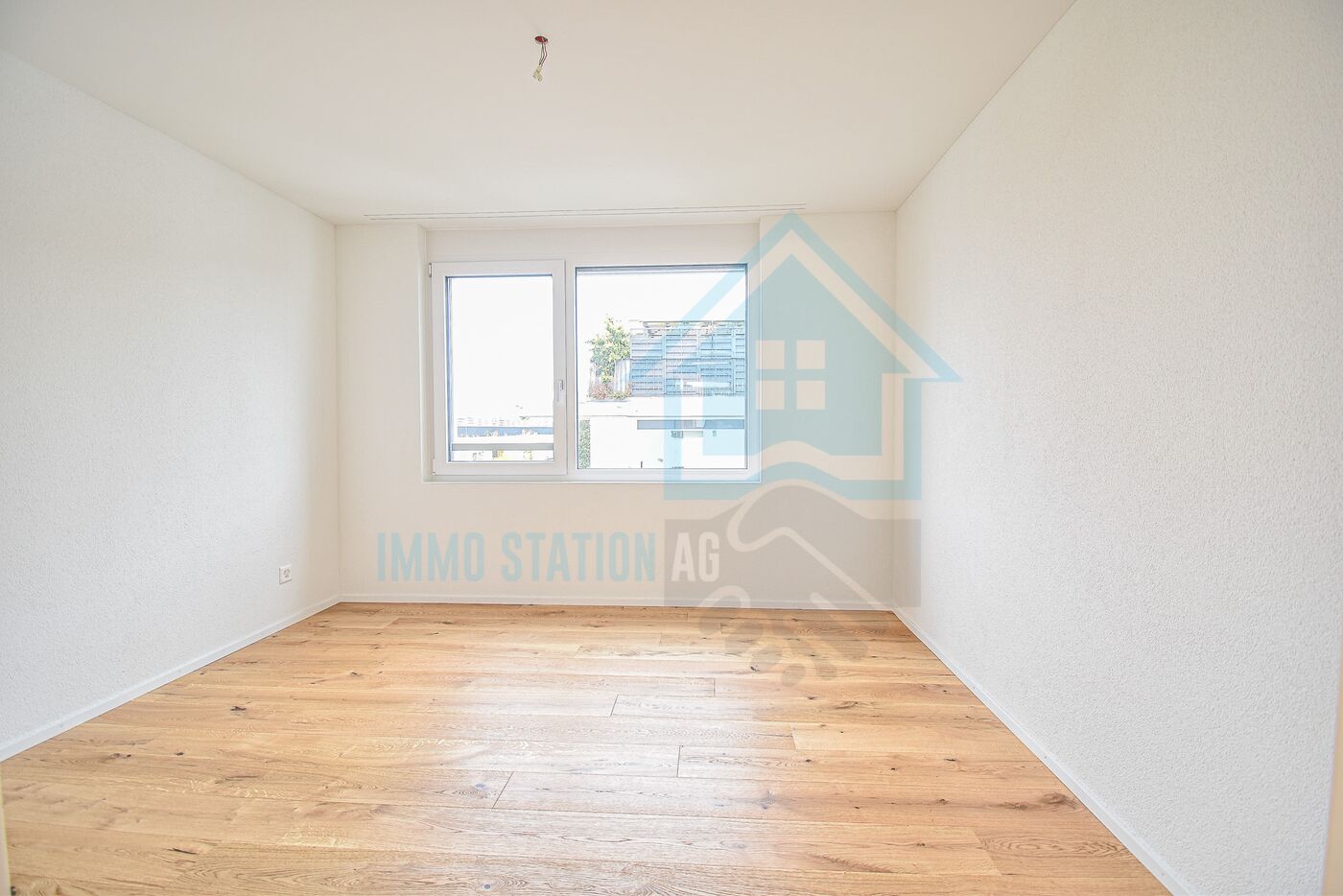 Heller leerer Raum mit Holzfußboden und Fenster