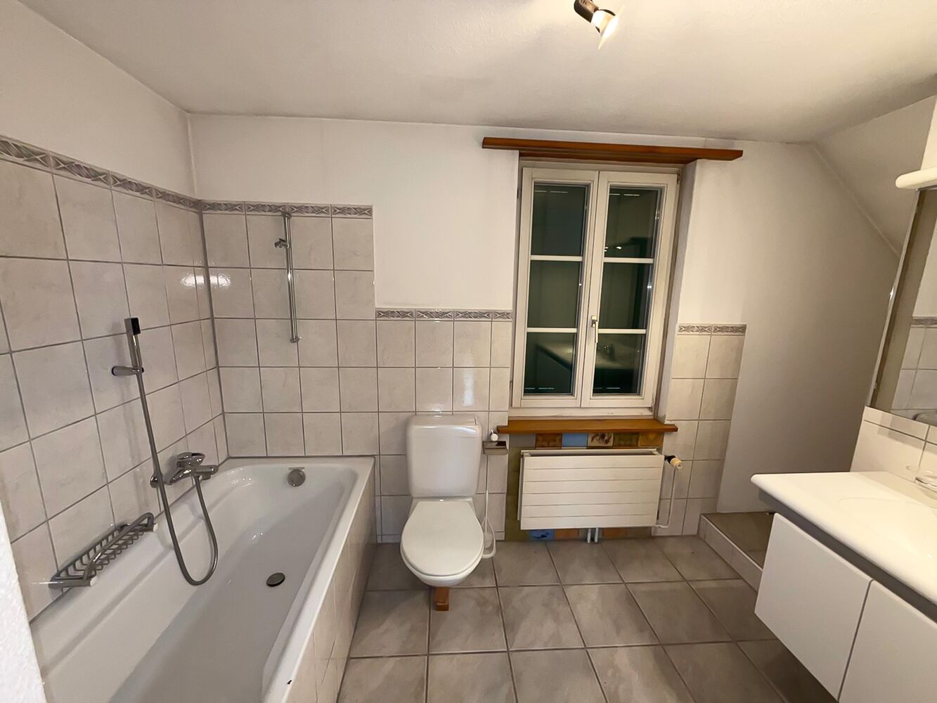 Badezimmer mit Wanne, WC und Fenster