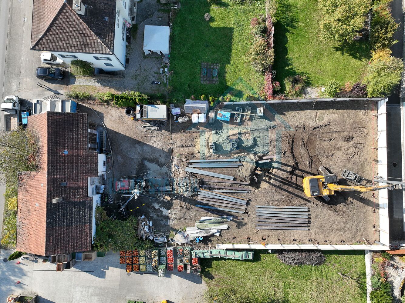 Luftaufnahme einer Baustelle mit Garten und Nachbargebäuden