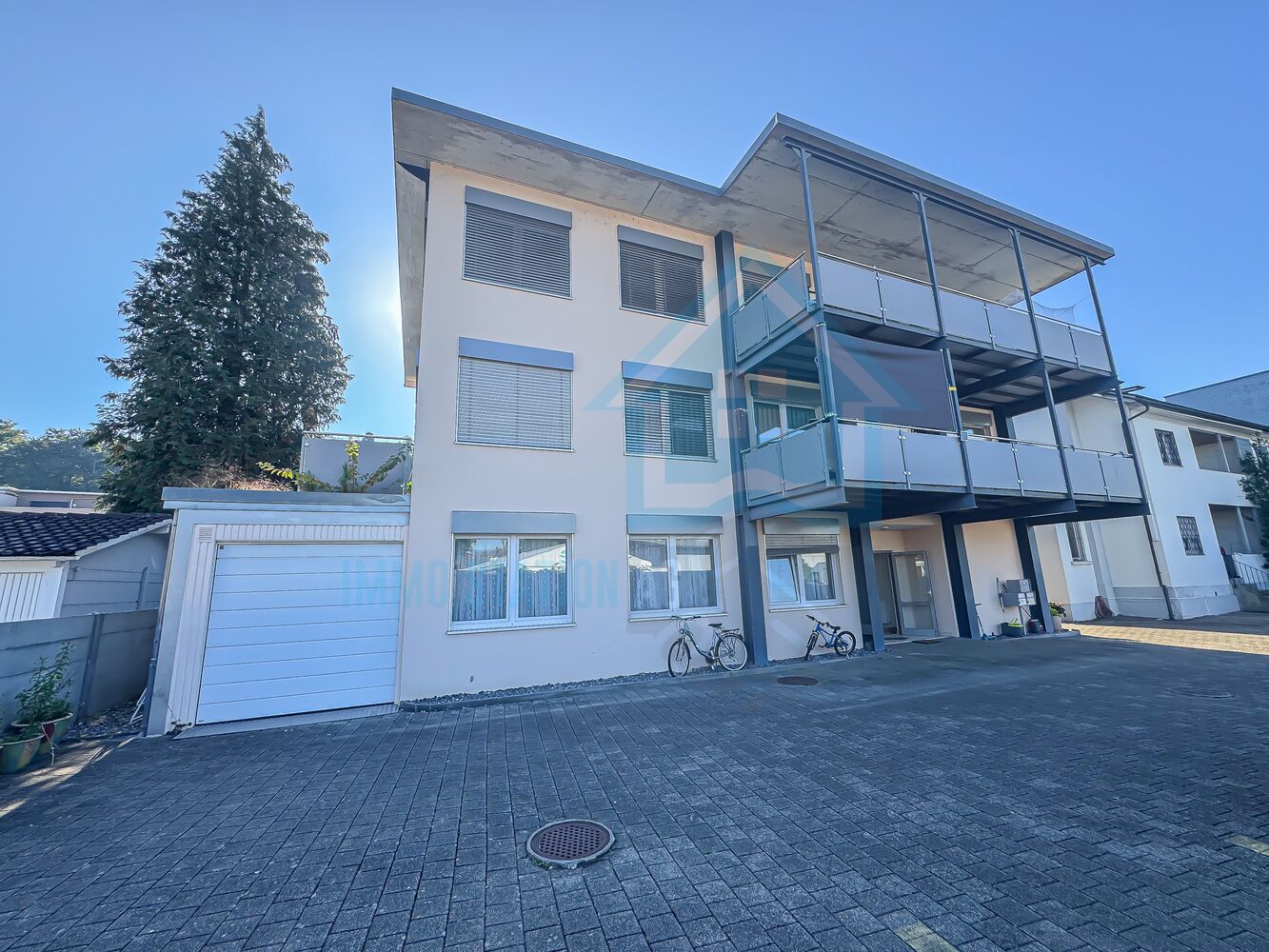 Modernes Mehrfamilienhaus mit Balkonen und Garagenzufahrt