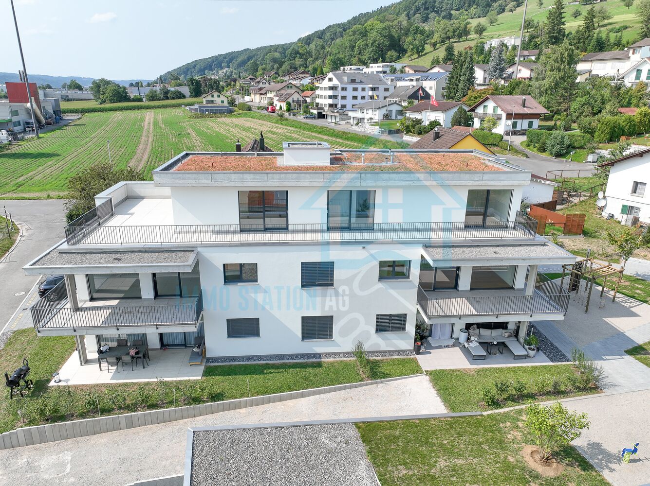 Modernes Mehrfamilienhaus mit Dachterrasse und Balkonen