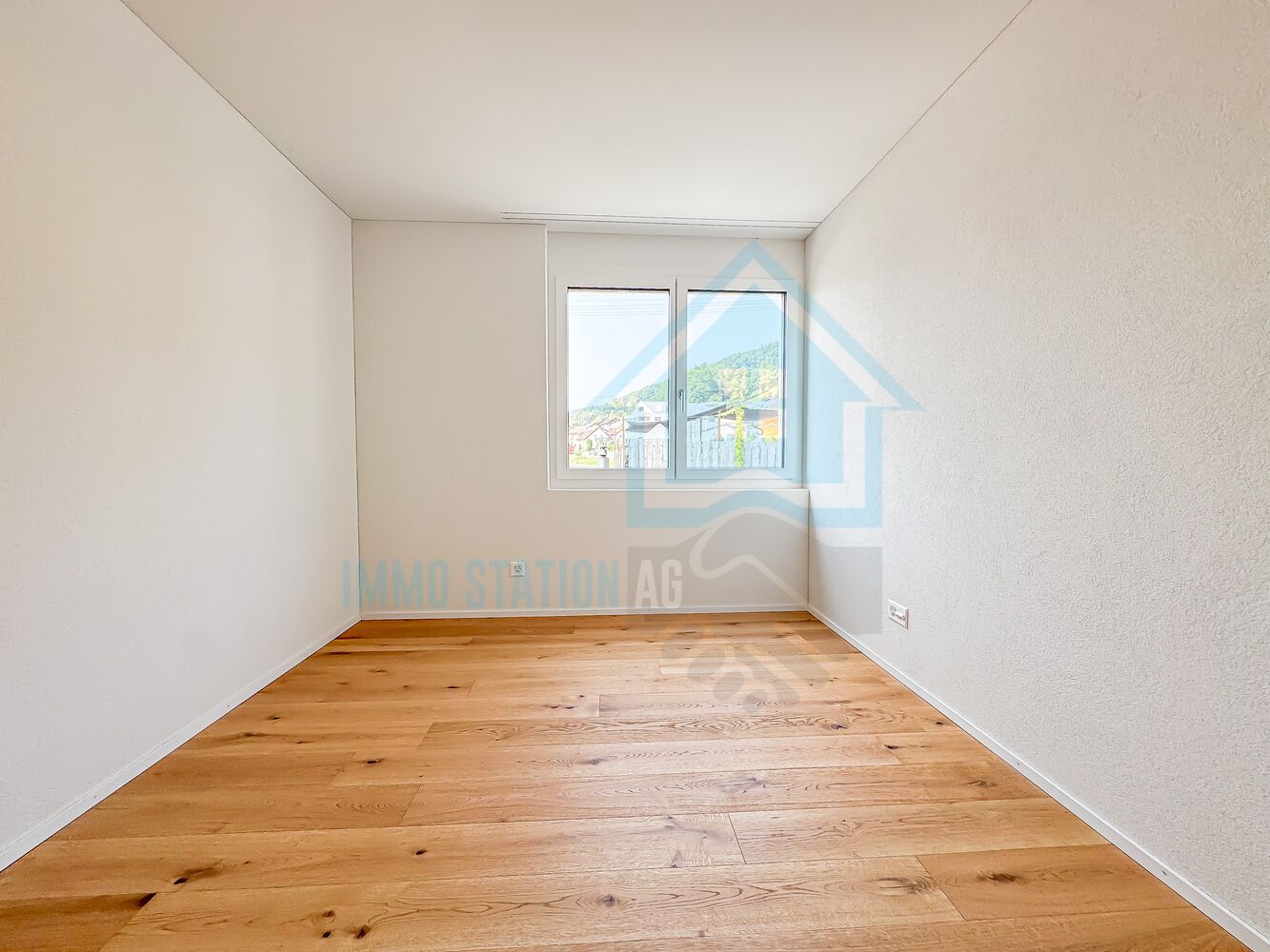 Leerer heller Raum mit Holzfußboden und Fenster