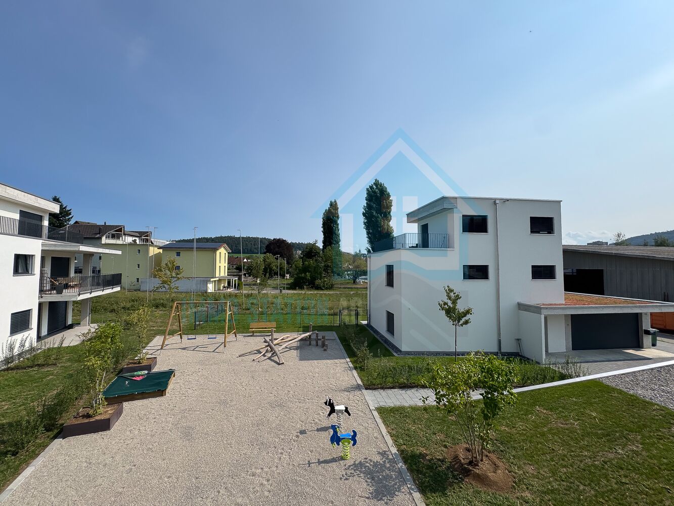 Außenansicht einer modernen Wohnanlage mit Spielbereich