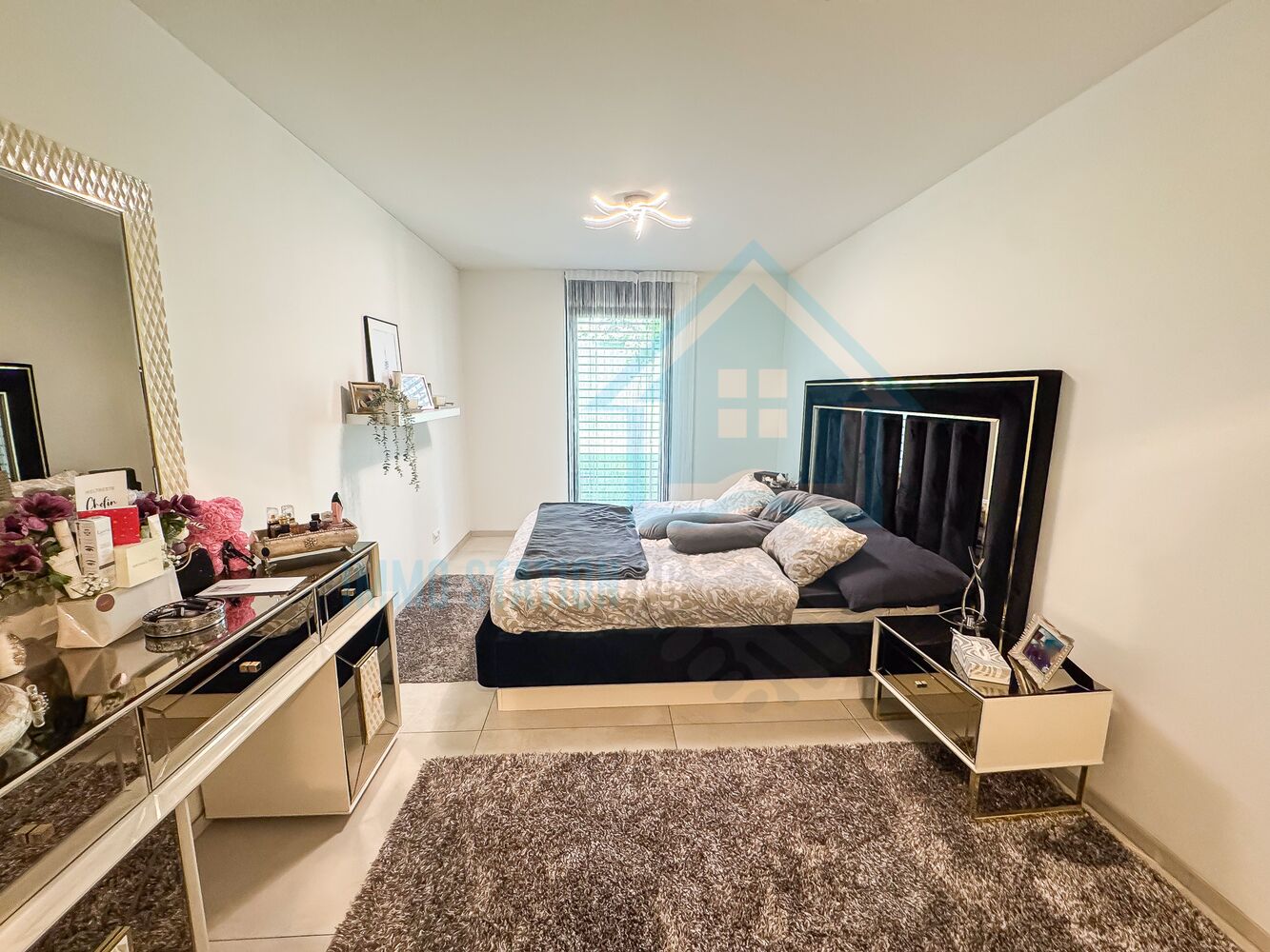 Modernes Schlafzimmer mit gepolstertem Bett und Spiegelfront-Möbeln