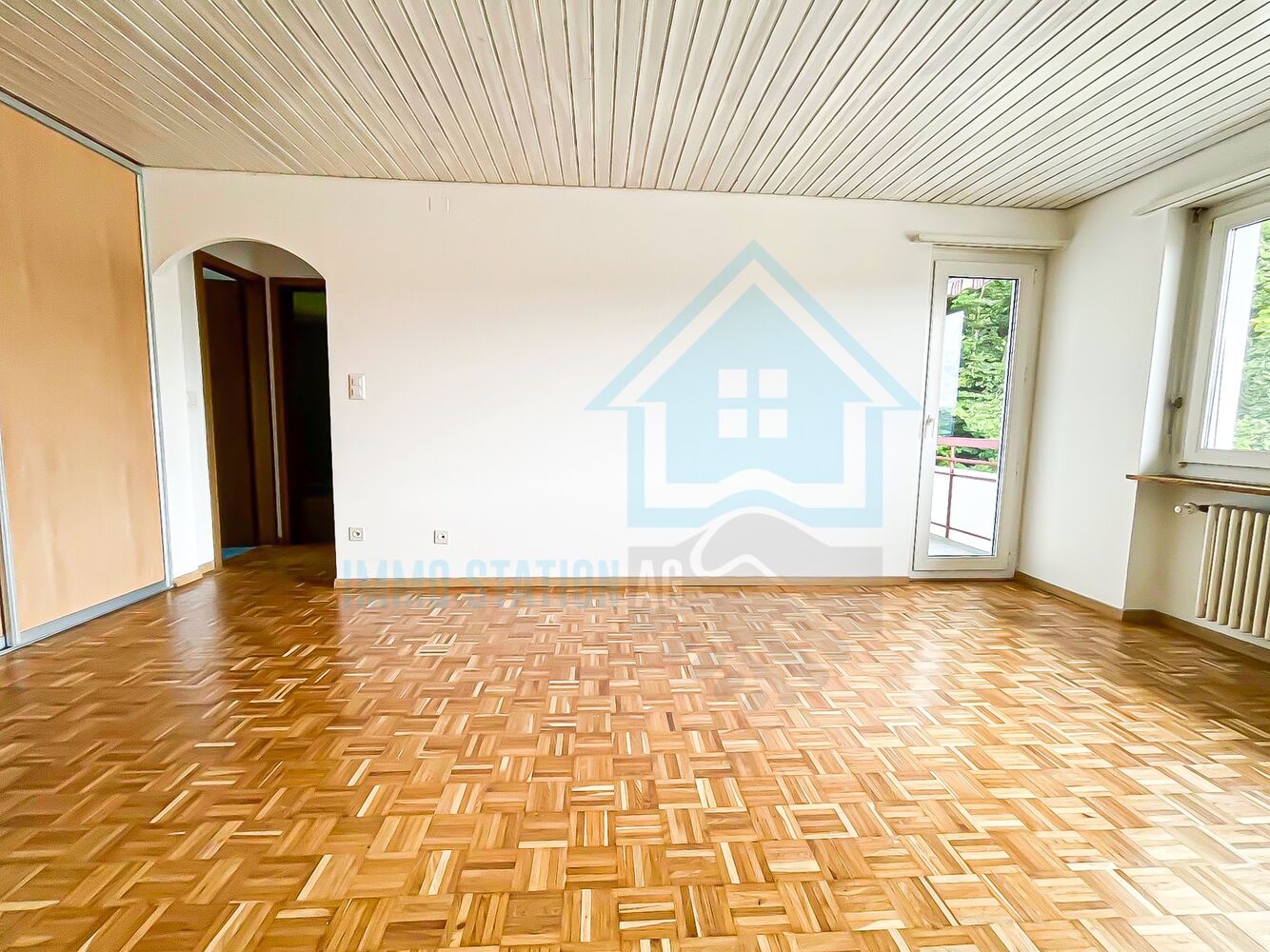 Leerer Wohnraum mit Parkett und Fenstern