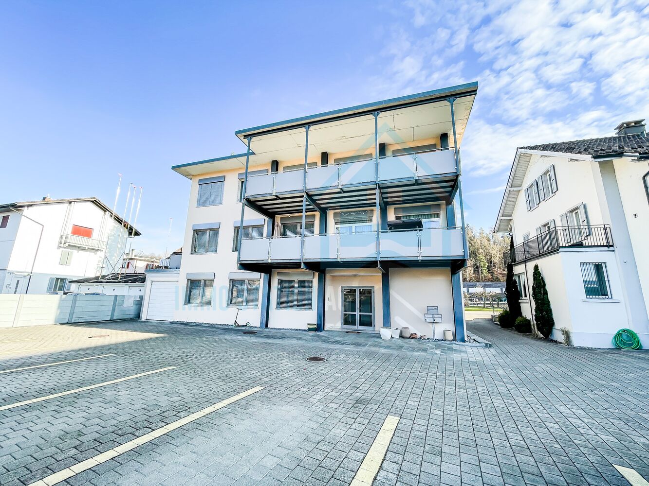 Mehrfamilienhaus mit Balkonen und Parkplatz