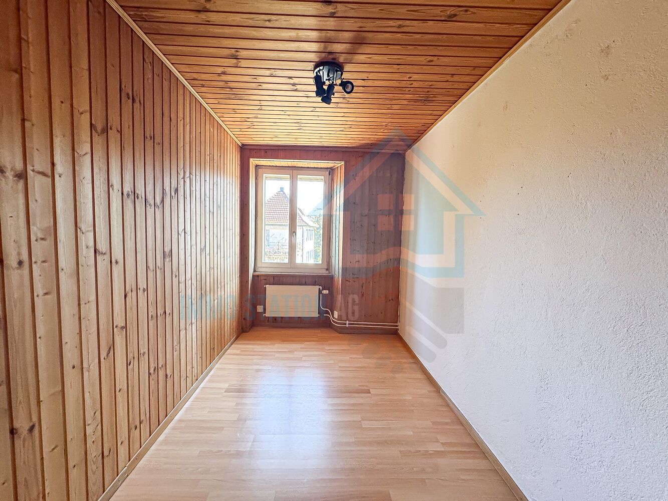 Schmaler, holzvertäfelter Raum mit Fenster