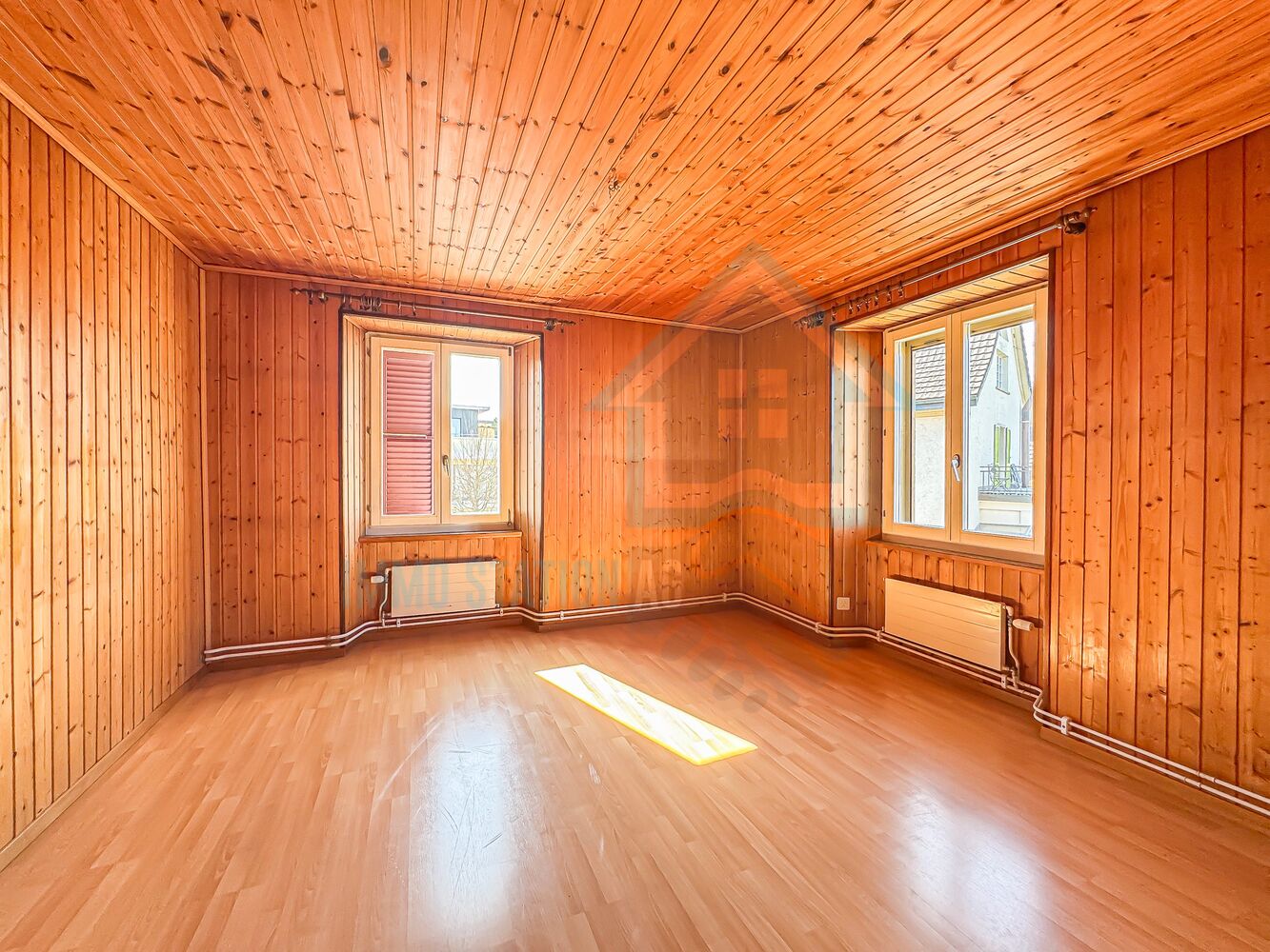 Holzgetäfelter leerer Raum mit zwei Fenstern