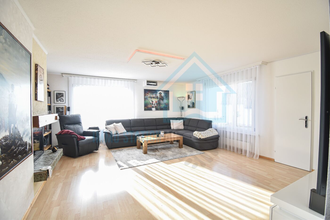 Helles Wohnzimmer mit Ecksofa und Kamin