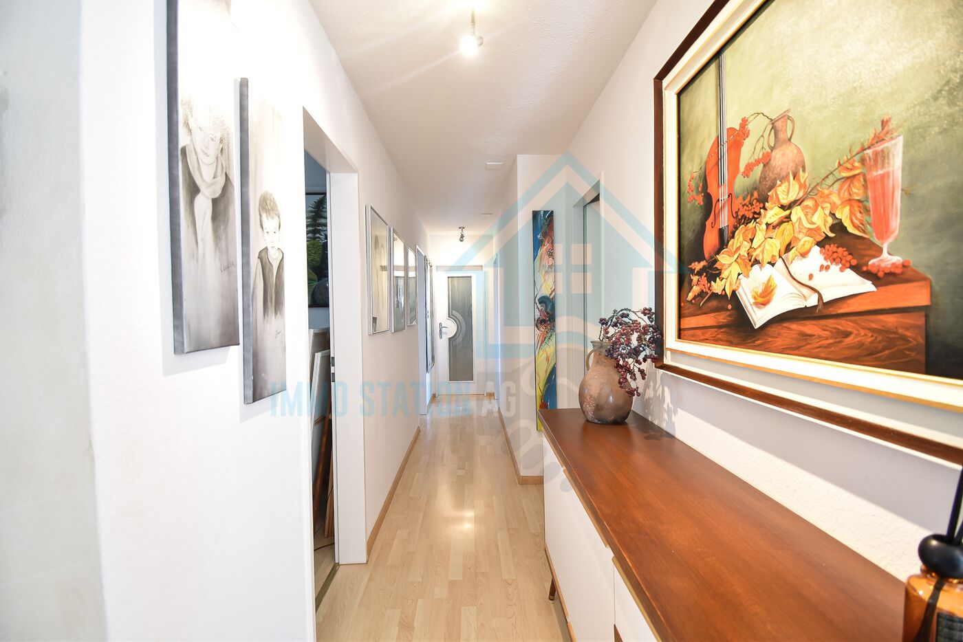 Heller Flur mit Kunst und Holzkonsole