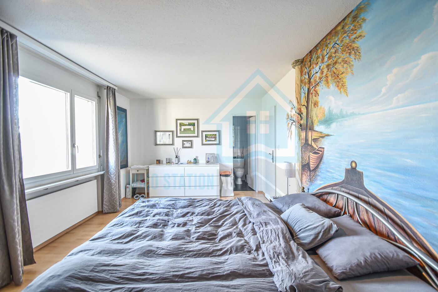 Schlafzimmer mit angrenzendem Bad und großem Wandmotiv